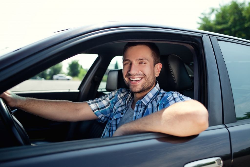 a young man in a driver's seat happy