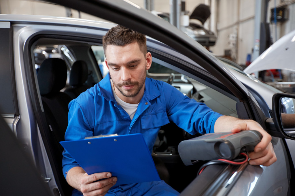 a man using a diagnostic scanner in a car