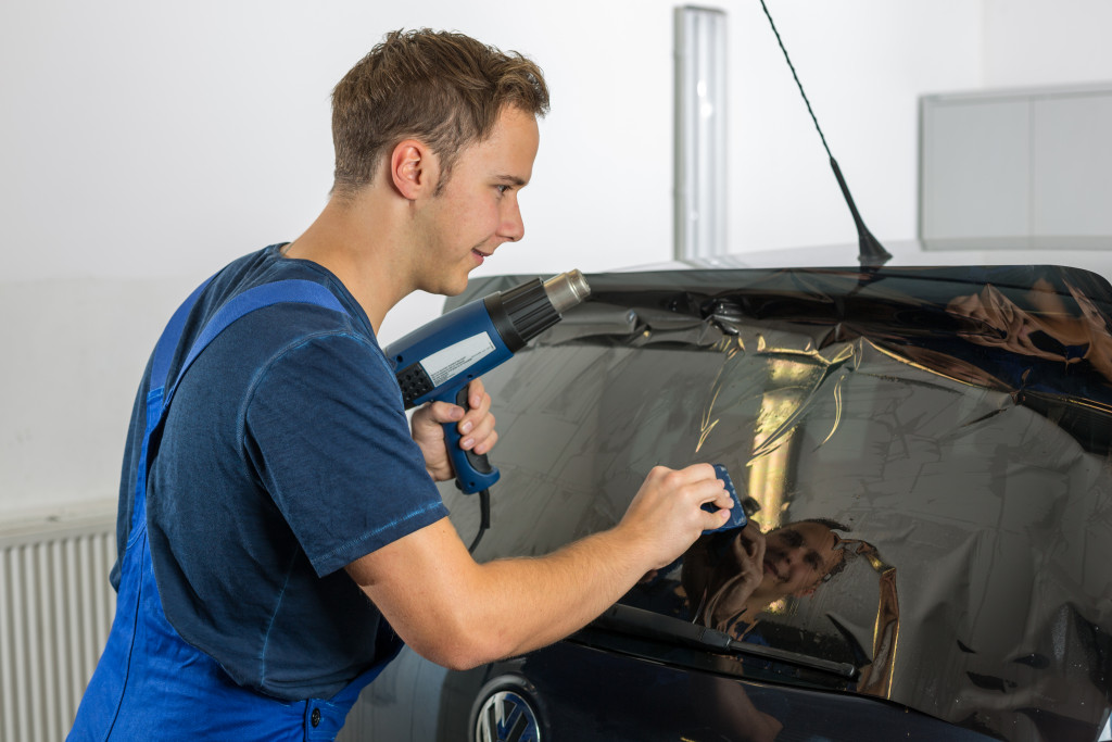 man installing car film at the rear window