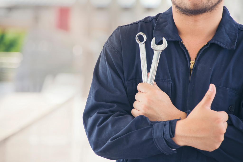 A car mechanic holding tools