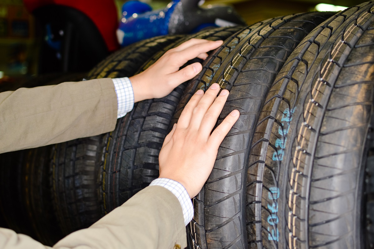 A hand choosing a car tire