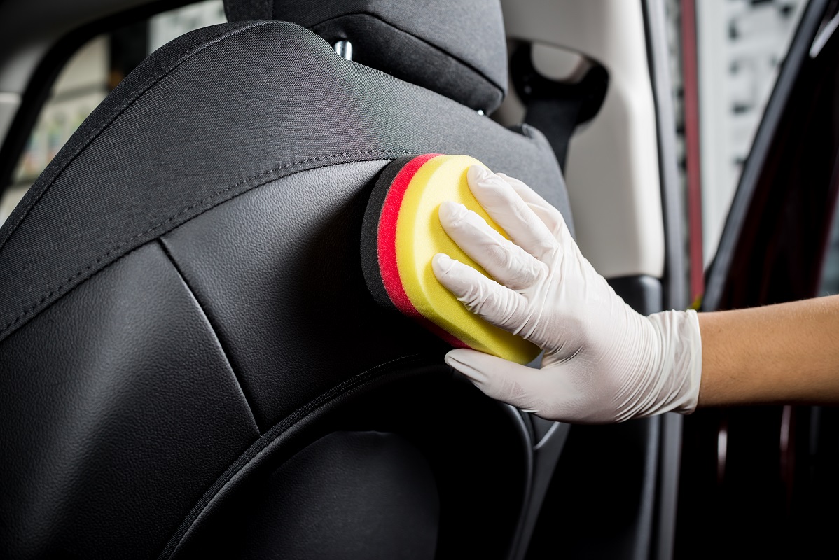 A hand polishing a car interior